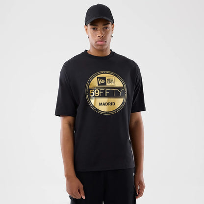 The model is wearing this New Era Sticker Madrid Oversized T-Shirt in black. 1