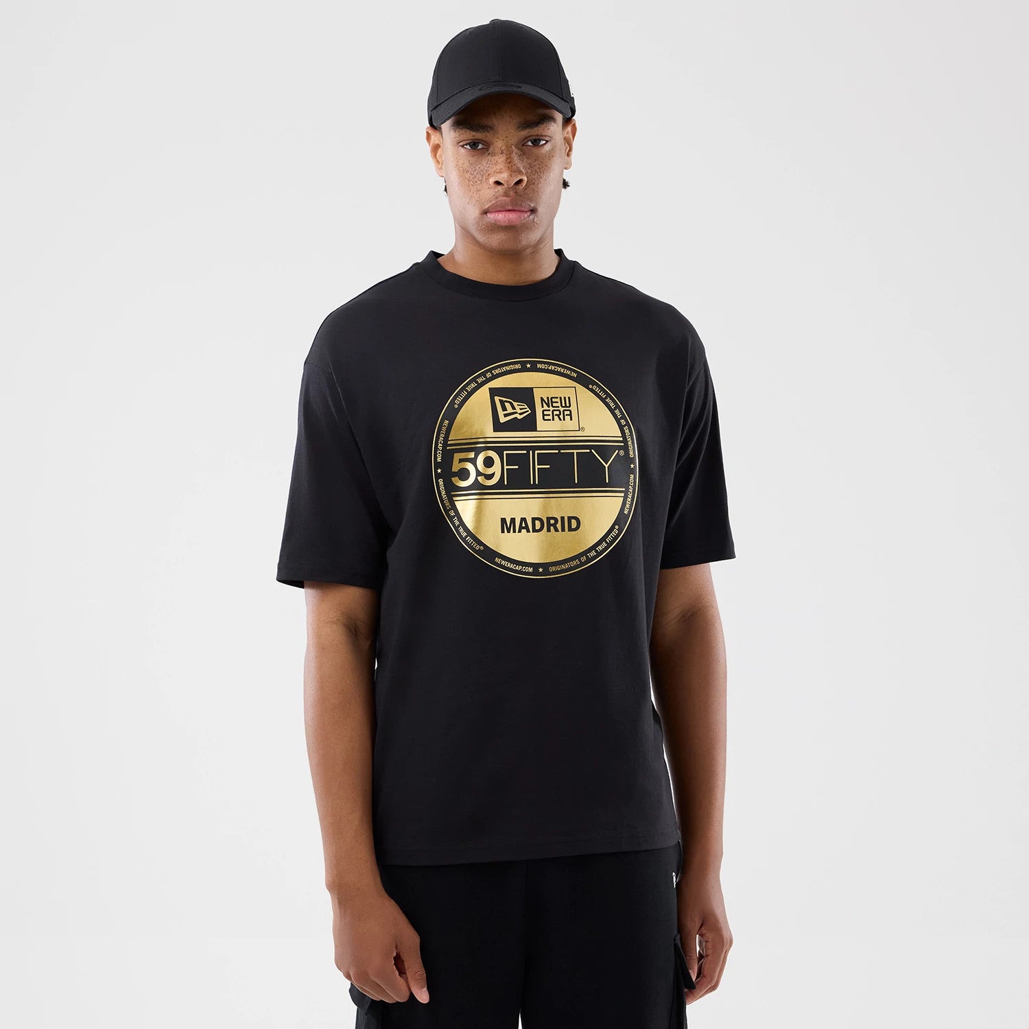 The model is wearing this New Era Sticker Madrid Oversized T-Shirt in black. 1