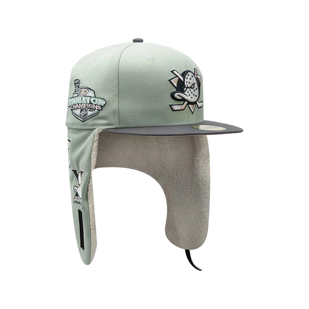 Anaheim Ducks NHL Patch Pastel Green New Era 59FIFTY Fitted Cap, three-quarter view showing the embroidered team logo on the front panel and Stanley Cup Champions patch on the left side, with grey flat visor and extended fleece-lined ear flaps.