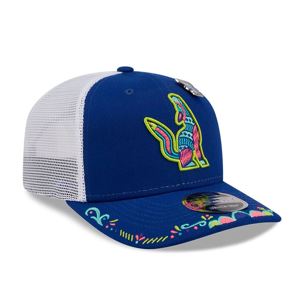 Hillsboro Hops MiLB La Copa 2026 Blue New Era 9SEVENTY Stretch Snap Adjustable Cap, three-quarter view showing the multicoloured raised embroidery of a stylised hop on the blue front panel, with decorative embroidery on the visor.