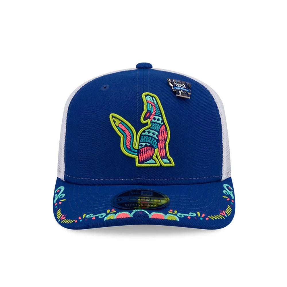 Hillsboro Hops MiLB La Copa 2026 Blue New Era 9SEVENTY Stretch Snap Adjustable Cap, front view showing a multicoloured embroidered fox logo on the blue crown, a floral pattern on the visor, and the 9SEVENTY size sticker centre front.