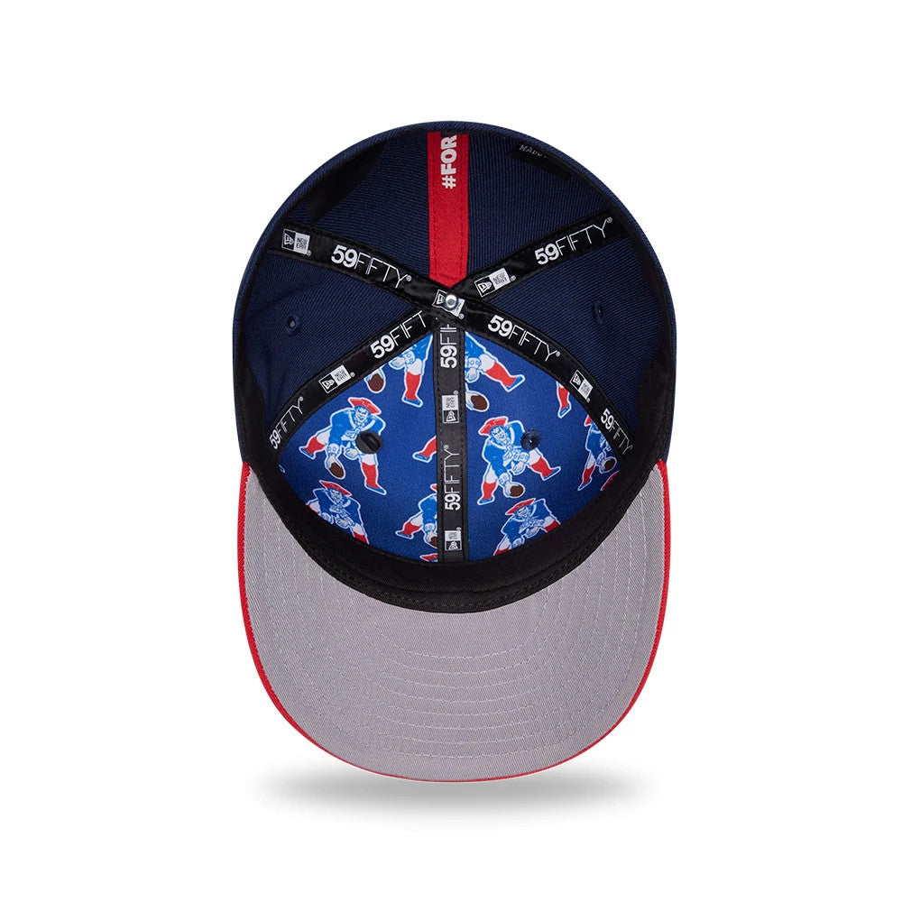 New England Patriots NFL Draft 2026 Dark Blue New Era 59FIFTY Fitted Cap, inside view showing the blue fabric lining with a repeating Pat Patriot graphic, black taping with white 59FIFTY branding, and a grey undervisor edged in red stitching.