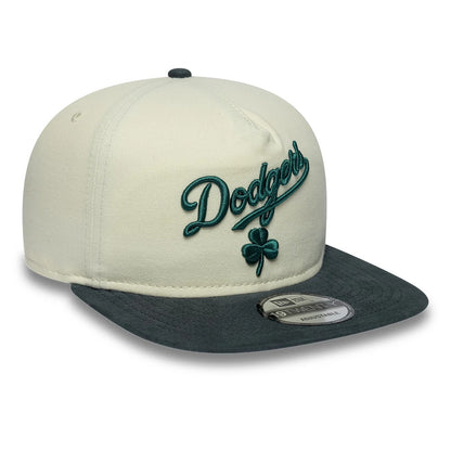 LA Dodgers MLB Metallic Logo Cream New Era 19TWENTY Adjustable Cap, three-quarter view showing the raised teal Dodgers script embroidery with a clover detail on the front cream panel, contrasted by a dark grey visor with a 19TWENTY size sticker.