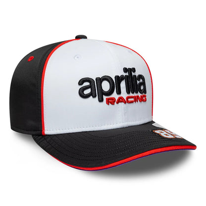 Aprilia Replica Jorge Martin White New Era 9SEVENTY Stretch Snap Adjustable Cap, three-quarter view showing a raised embroidered black aprilia and red RACING logo on the white front panel, with a contrasting black visor and a 9SEVENTY size sticker.