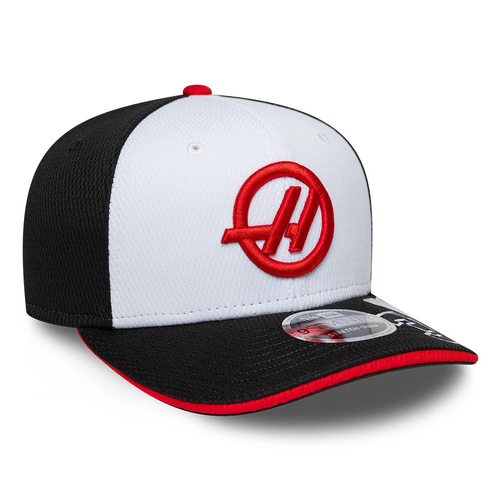 TGR Haas F1 Esteban Ocon Black New Era 9SEVENTY Stretch Snap Adjustable Cap, three-quarter view showing a red embroidered A logo on the white front panel, a black visor with a red edge, and a 9SEVENTY size sticker.