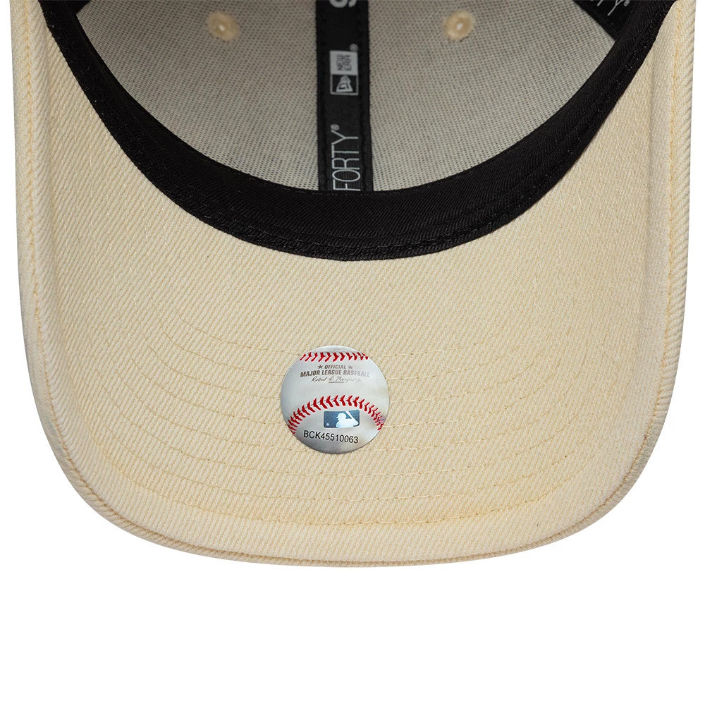 New York Mets MLB Washed Denim Light Beige New Era 9FORTY Adjustable Cap, inside view showing a light beige undervisor with a baseball-themed sticker, black taping with branding, and circular beige reinforcement around the eyelets.