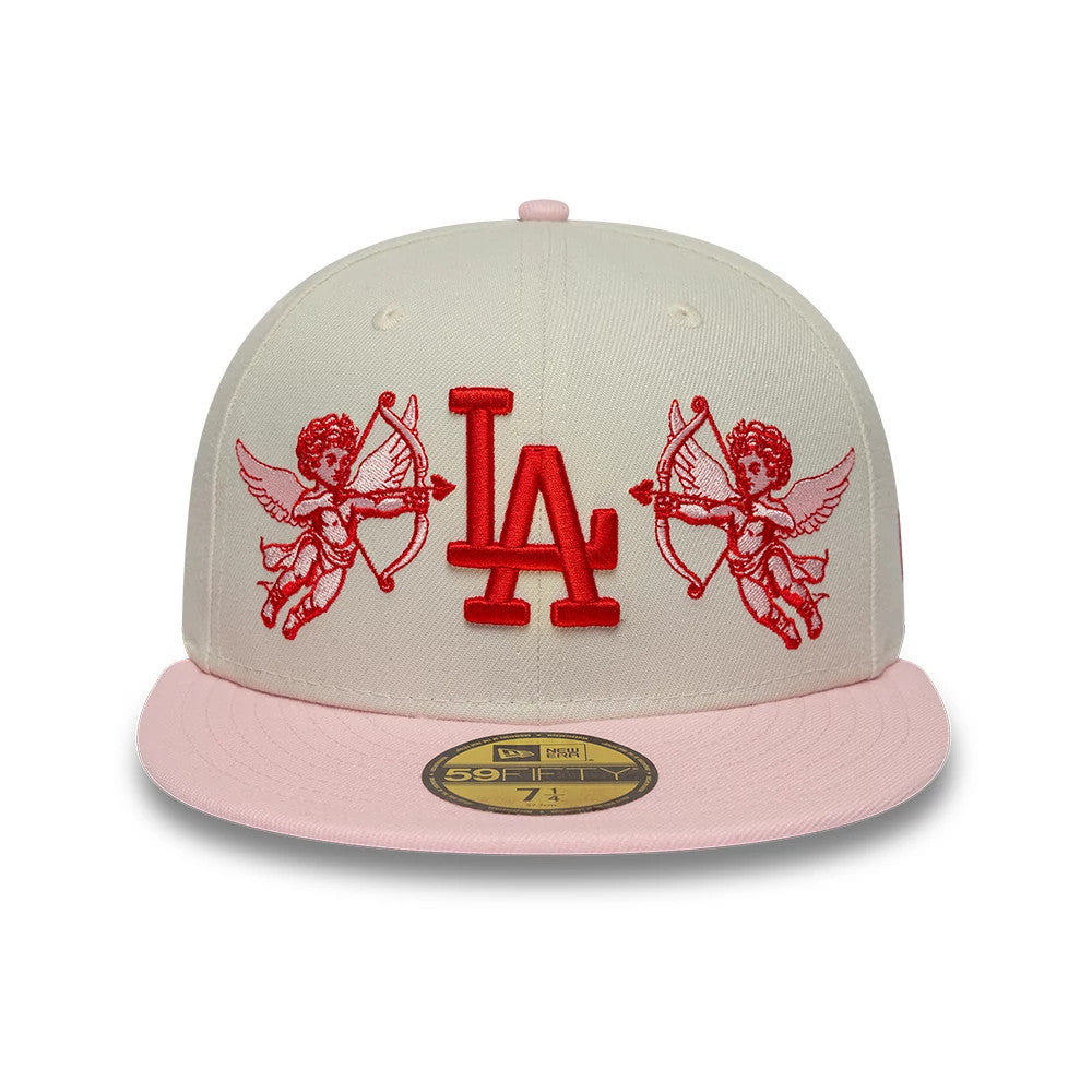 LA Dodgers MLB Cherub Cream & Pink New Era 59FIFTY Fitted Cap, front view showing the red LA logo in raised embroidery on the cream crown, with cherub graphics on either side and a pink flat visor with a gold 59FIFTY size sticker.