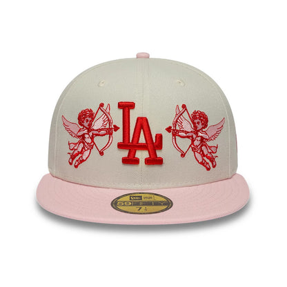 LA Dodgers MLB Cherub Cream & Pink New Era 59FIFTY Fitted Cap, front view showing the red LA logo in raised embroidery on the cream crown, with cherub graphics on either side and a pink flat visor with a gold 59FIFTY size sticker.