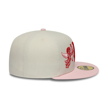 LA Dodgers MLB Cherub Cream & Pink New Era 59FIFTY Fitted Cap, three-quarter view showing the red cherub embroidery on the front panel, a flat cream crown with pink top button and eyelets, and a flat pink visor with a gold 59FIFTY size sticker.