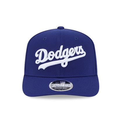 LA Dodgers MLB Dark Blue New Era 9SEVENTY Stretch Snap Adjustable Cap, front view showing the white embroidered Dodgers script logo on the structured dark blue crown, complemented by a slightly curved visor and 9SEVENTY size sticker.