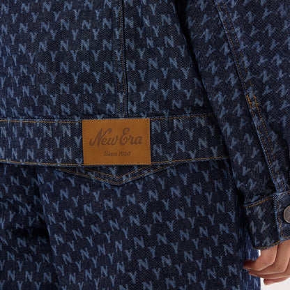 New Era New York Yankees Womens MLB Denim Navy Jacket, close-up showing an all-over N pattern on the navy denim fabric, a brown patch with a debossed New Era logo above the hem, and button detail on the cuff.
