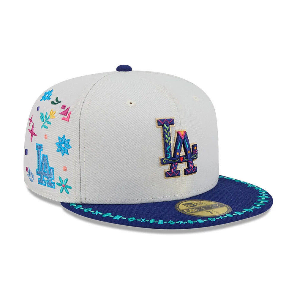 LA Dodgers MLB Heritage Light Beige New Era 59FIFTY Fitted Cap, three-quarter view showing a multicoloured embroidered LA logo on the front panel, a dark blue visor with decorative embroidery along the edge, and a 59FIFTY size sticker.
