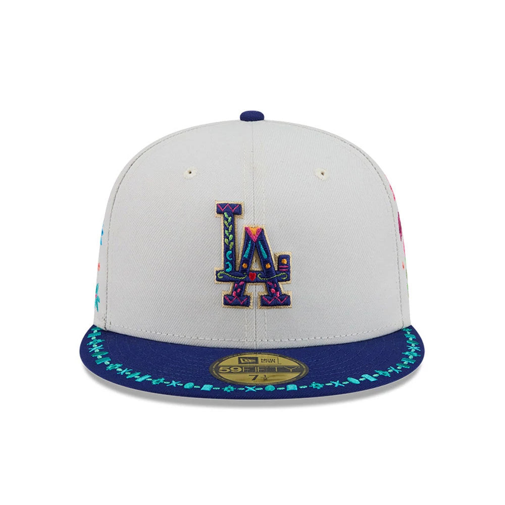 LA Dodgers MLB Heritage Light Beige New Era 59FIFTY Fitted Cap, front view showing a multicoloured embroidered LA logo on the central beige panel, with a patterned blue visor featuring contrasting stitching and a gold 59FIFTY size sticker.