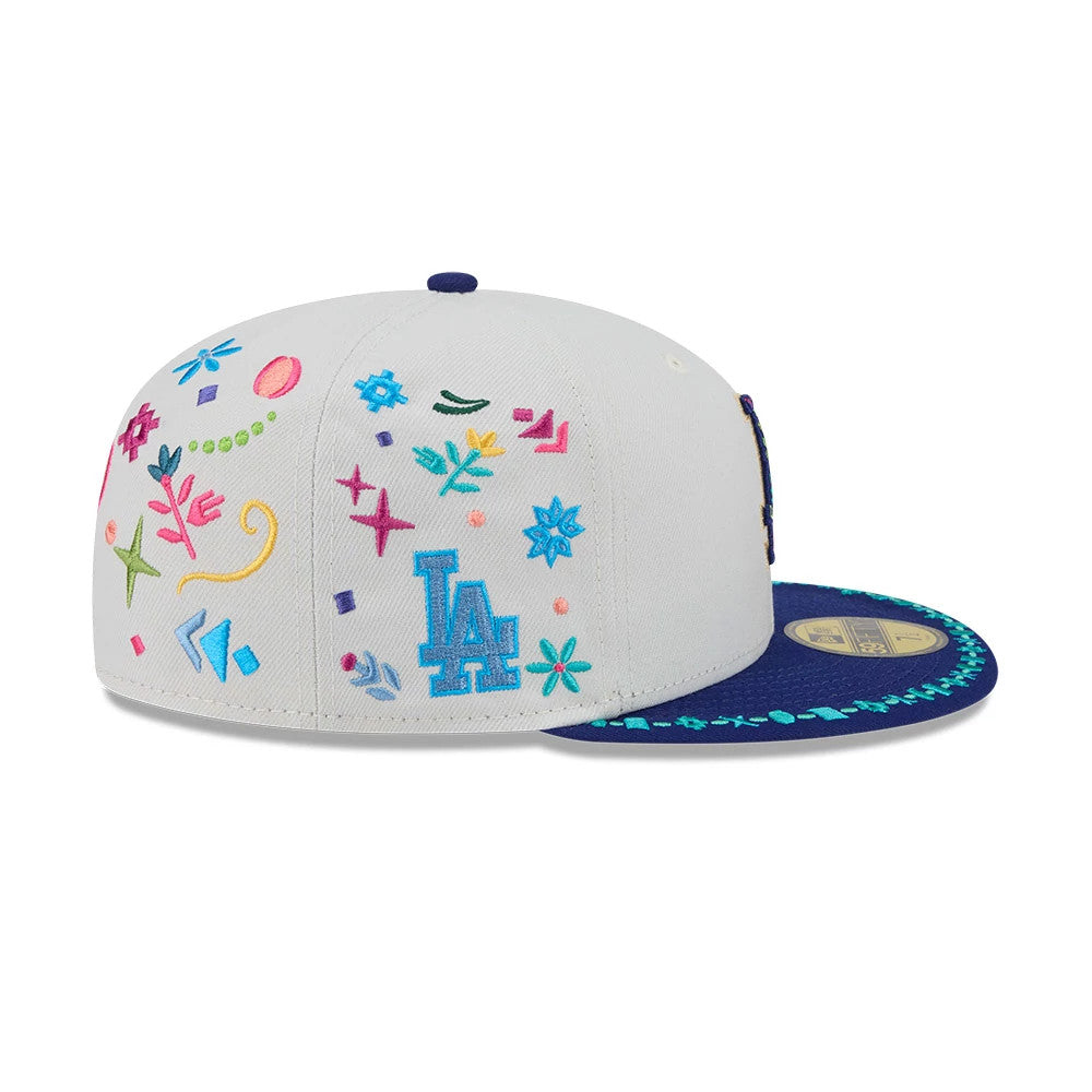 LA Dodgers MLB Heritage Light Beige New Era 59FIFTY Fitted Cap, side view showing a colourful array of embroidered motifs, including flowers and stars, with the blue LA logo on the side panel and a blue visor decorated with green stitching.