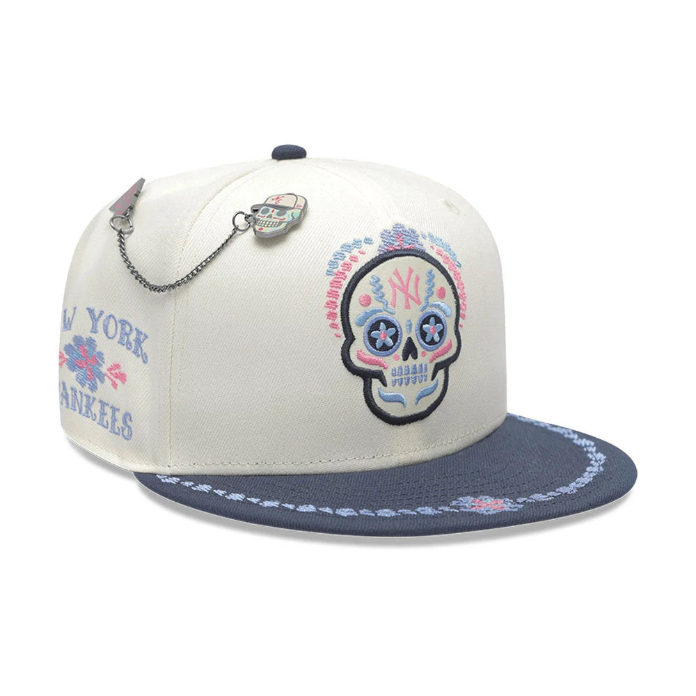 Pictured is this MLB Day Of The Dead New York Yankees 59FIFTY Fitted cap in light beige & dark blue. 1