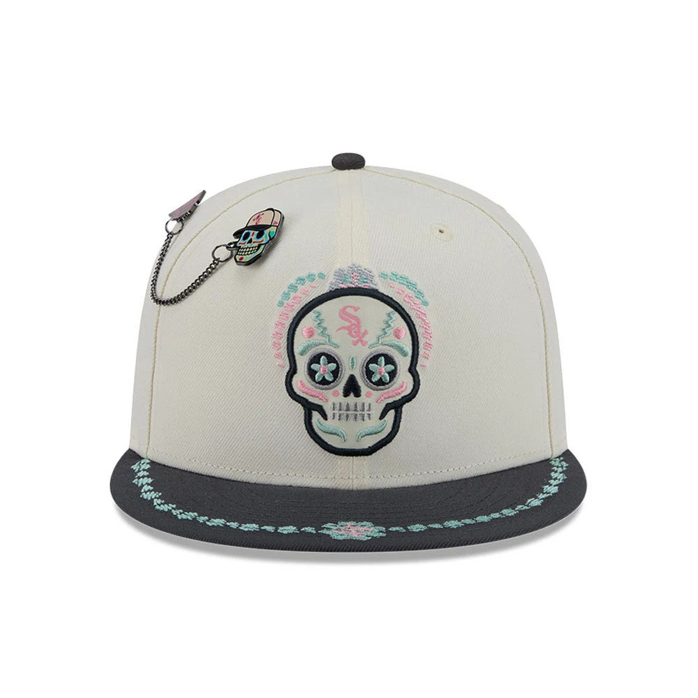 White Sox MLB Day Of The Dead Light Beige & Black New Era 59FIFTY Fitted Cap, front view showing an intricately embroidered sugar skull design on the front panel, a colourful border on the black visor, and a skull pin attached by a chain.