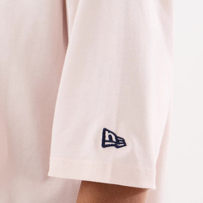 New Era New York Yankees Womens MLB Graphic Pastel Pink T-Shirt, side view showing a soft pastel pink sleeve with a navy blue embroidered New Era logo near the hem, capturing a close-up of the sleeve's gentle drape.