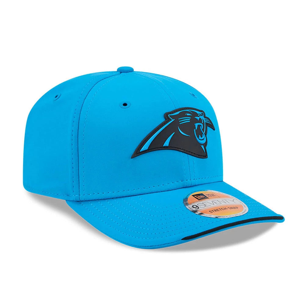 Panthers NFL Sideline 2026 Blue New Era 9SEVENTY Stretch Snap Adjustable Cap, three-quarter view showing the raised black embroidered panther logo on the front panel, curved blue visor with a black edge, and 9SEVENTY size sticker.
