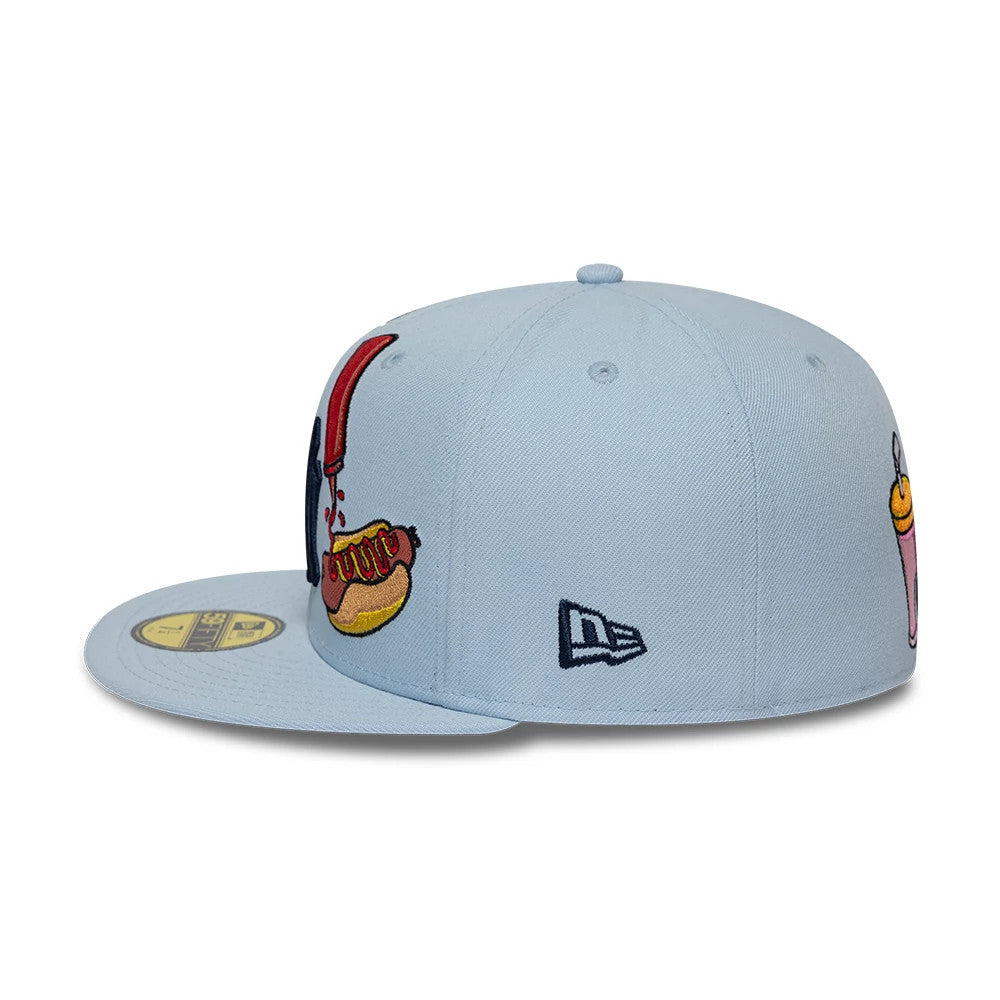 New York Yankees MLB Food Pastel Blue New Era 59FIFTY Fitted Cap, side view showing a navy embroidered New Era flag logo on the left panel, a raised hot dog graphic on the front and a pale blue flat visor with a gold 59FIFTY size sticker.