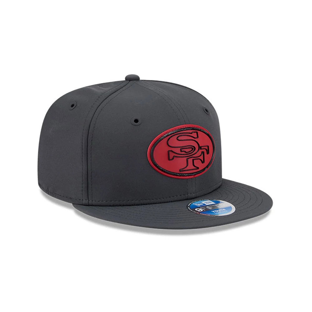 49ers Youth NFL Sideline 2026 Charcoal New Era 9FIFTY Snapback Adjustable Cap, three-quarter view showing the raised red SF logo on the dark charcoal front panels, a flat charcoal visor, and a 9FIFTY size sticker on the visor.