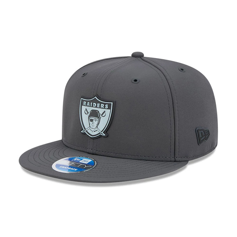 Raiders NFL Sideline 2026 Charcoal New Era 9FIFTY Snapback Adjustable Cap, front view showing an embroidered grey and black Raiders logo on the structured charcoal crown, with a flat visor and a 9FIFTY size sticker on top.