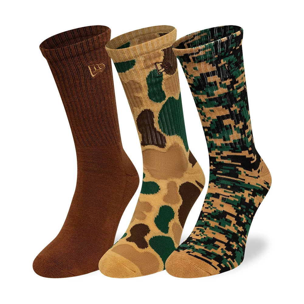 New Era Camo Brown 3 Pack Crew Socks, front view showing three distinct styles with an embroidered New Era logo on the ribbed tops: solid brown, green and brown camo, and digital black and green camo patterns.