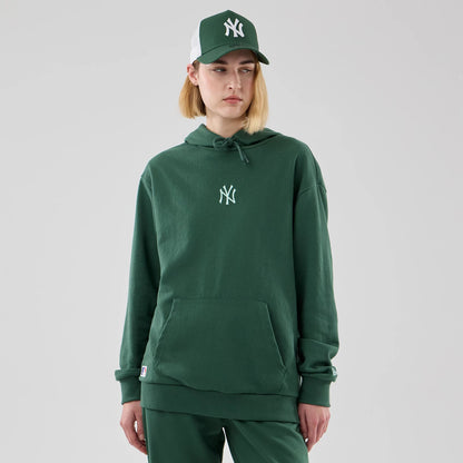 The model is wearing this MLB Midi League Essential New York Yankees Oversized Pullover Hoodie in dark green. 4
