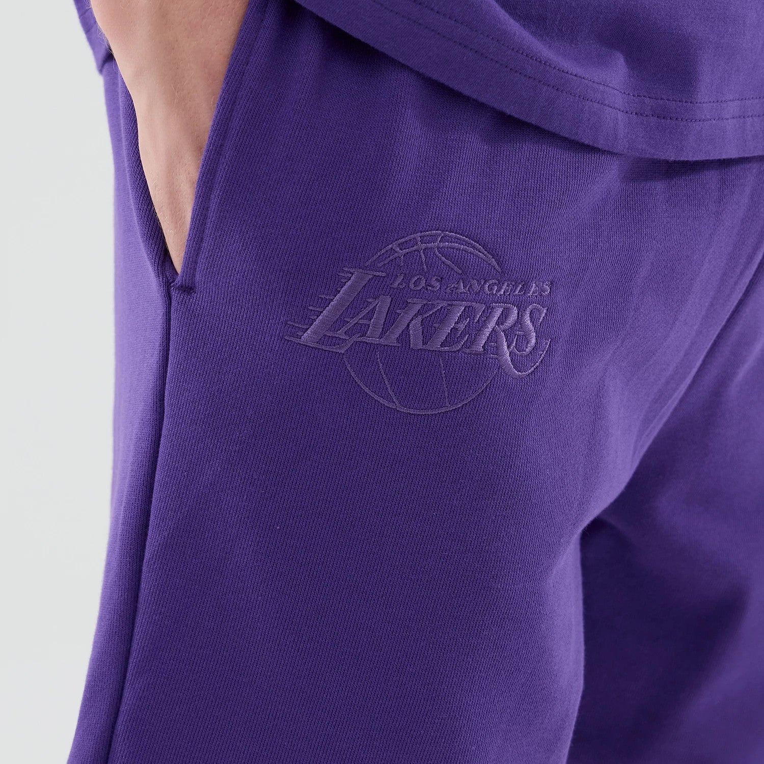 The model is wearing these NBA League Essential LA Lakers Oversized Shorts in purple. 4