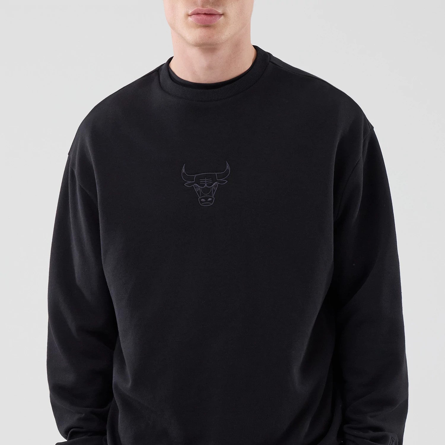 The model is wearing this NBA League Essential Chicago Bulls Oversized Crew Neck Sweater in black. 3