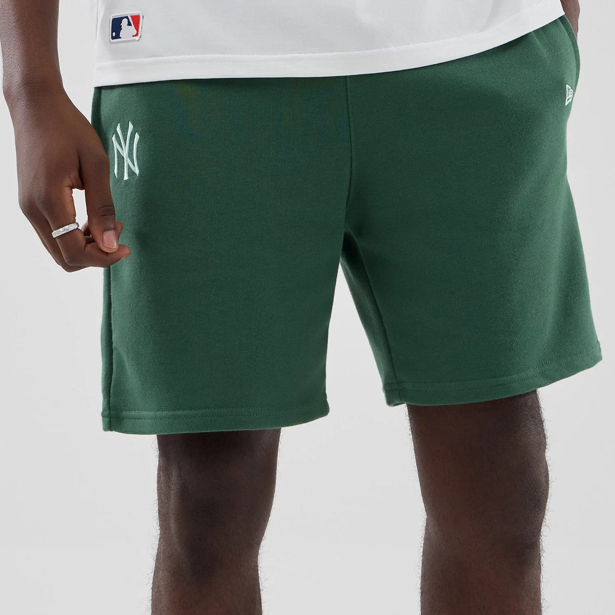 The model is wearing these MLB Midi League Essential New York Yankees Oversized Shorts in dark green. 3