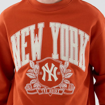 The model is wearing this MLB Arch Graphic New York Yankees Oversized Crew Neck Sweater in Orange. 5
