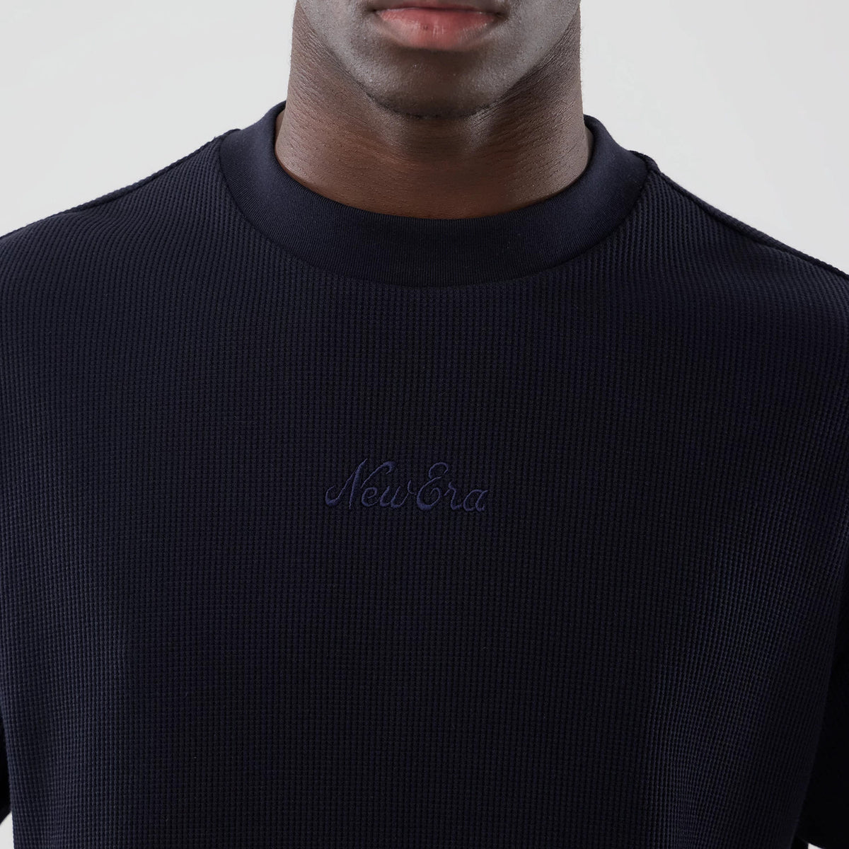 New Era Waffle Navy Boxy T-Shirt, front view showing the textured navy fabric with an embroidered New Era logo centred on the chest, a crew neckline, and the boxy fit as seen on a model from the shoulders down.