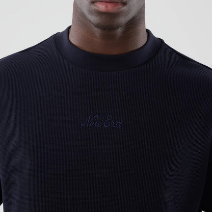 New Era Waffle Navy Boxy T-Shirt, front view showing the textured navy fabric with an embroidered New Era logo centred on the chest, a crew neckline, and the boxy fit as seen on a model from the shoulders down.