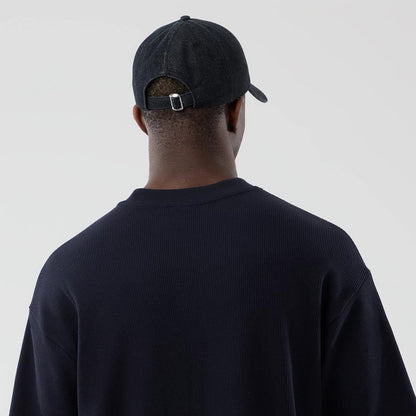 New Era Waffle Navy Boxy T-Shirt, back view on a model wearing a dark cap showing the textured navy fabric across the shoulders, with a rounded neckline and a relaxed fit silhouette seen from the rear.