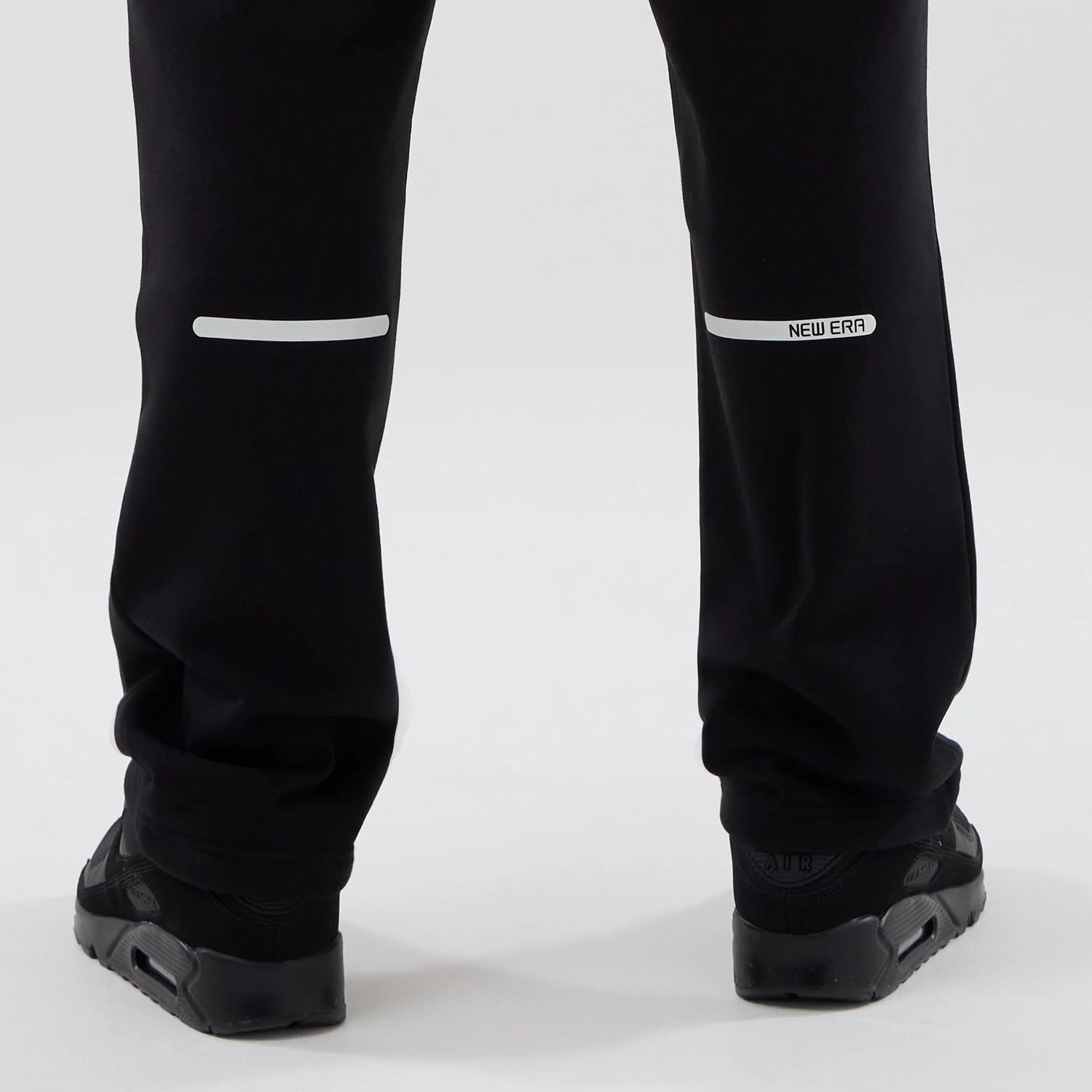 The model is wearing these New Era Tech Reflective Straight Leg Joggers in black. 7