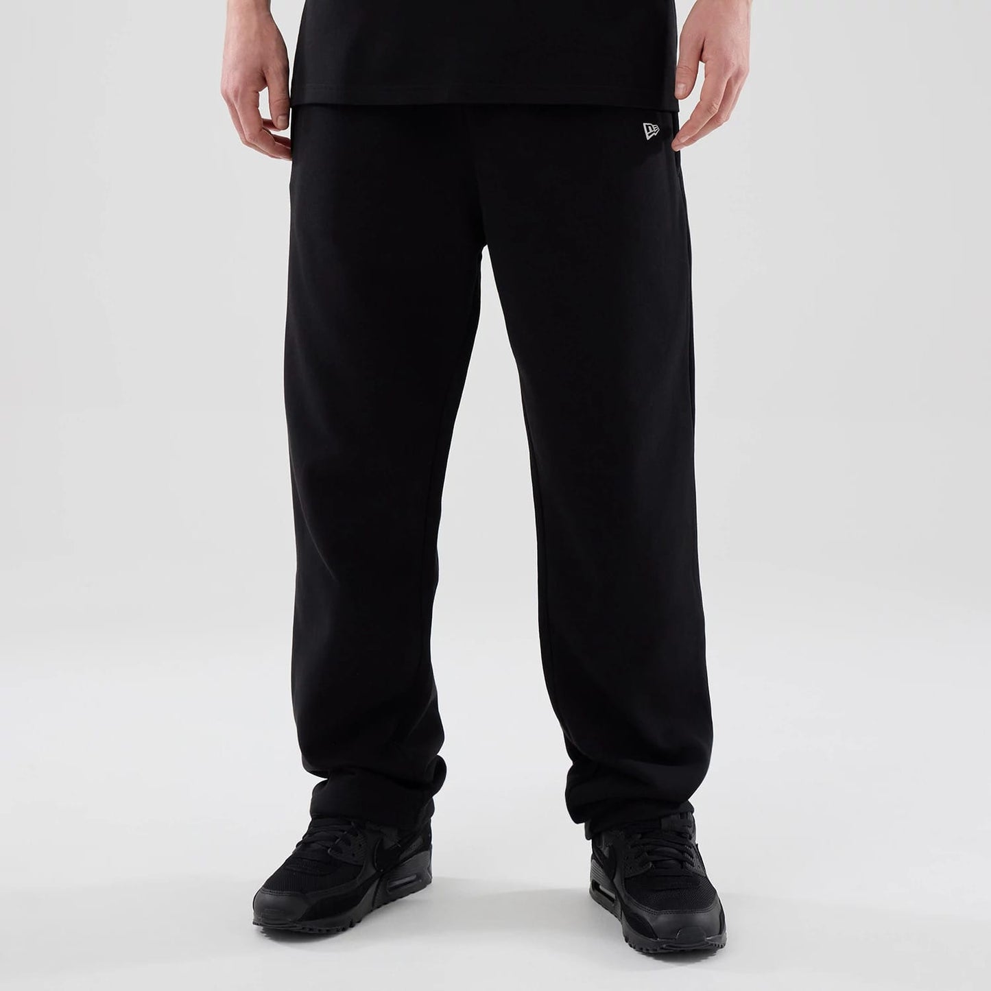 The model is wearing these New Era Tech Reflective Straight Leg Joggers in black. 1