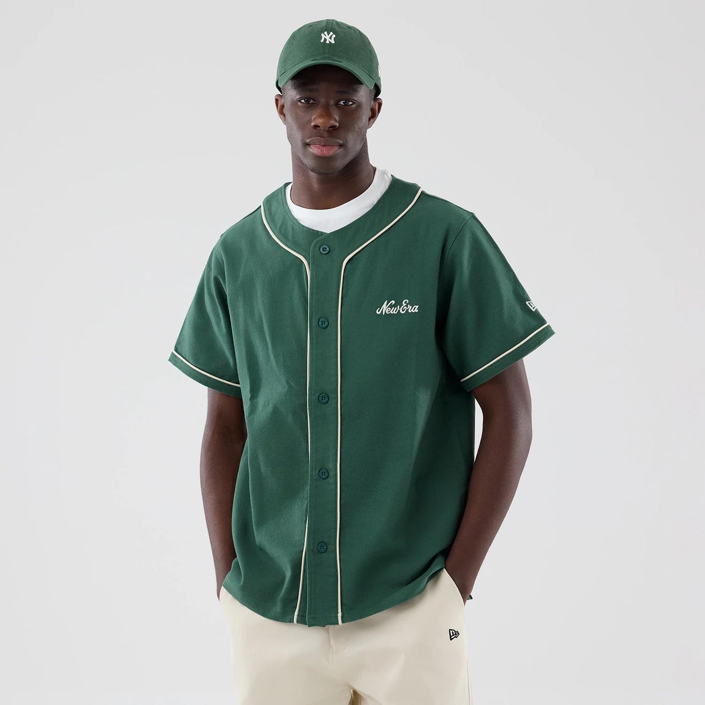 The model is wearing this New Era Baseball Jersey in dark green. 3