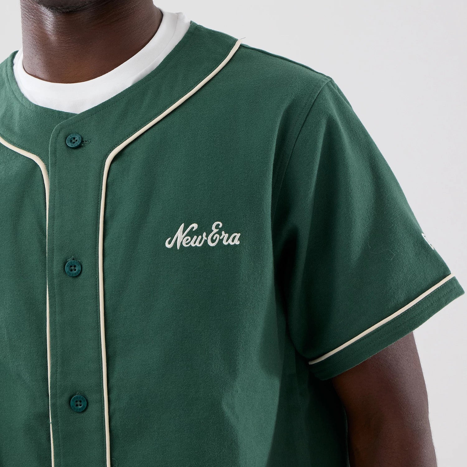 The model is wearing this New Era Baseball Jersey in dark green. 5