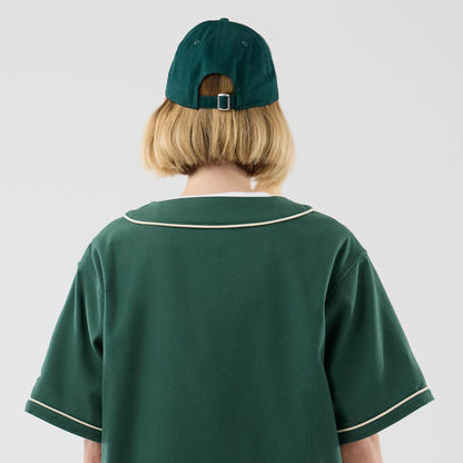 The model is wearing this New Era Baseball Jersey in dark green. 8