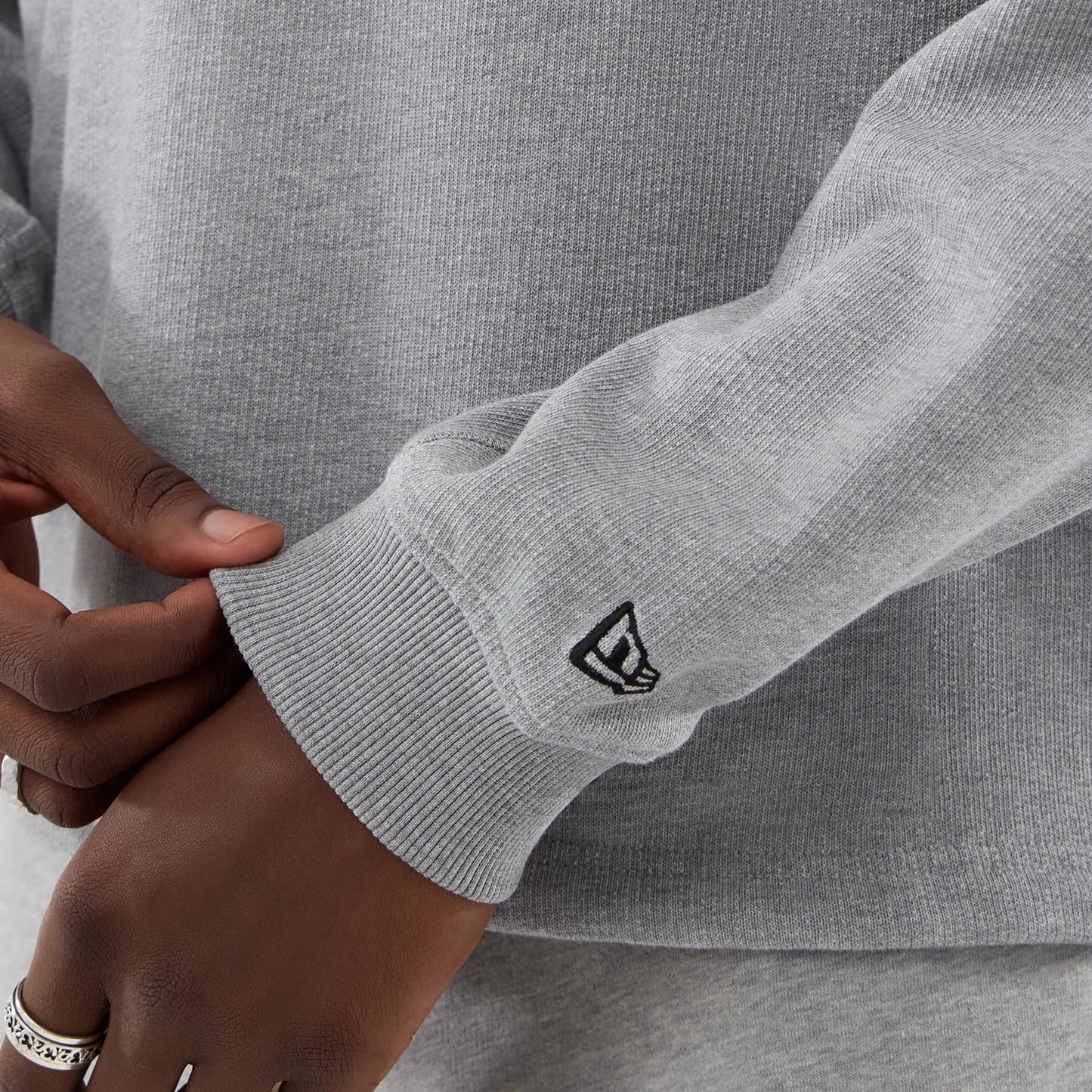 The model is wearing this New Era Oversized Crew Neck Sweater in grey. 5