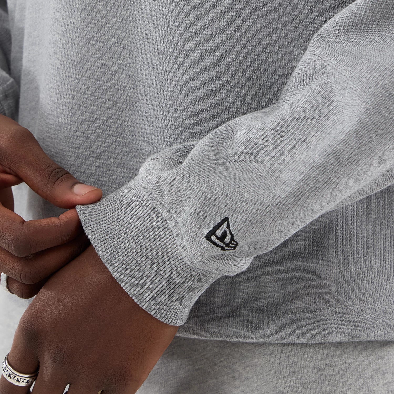 The model is wearing this New Era Oversized Crew Neck Sweater in grey. 5