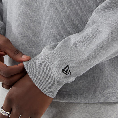 The model is wearing this New Era Oversized Crew Neck Sweater in grey. 5