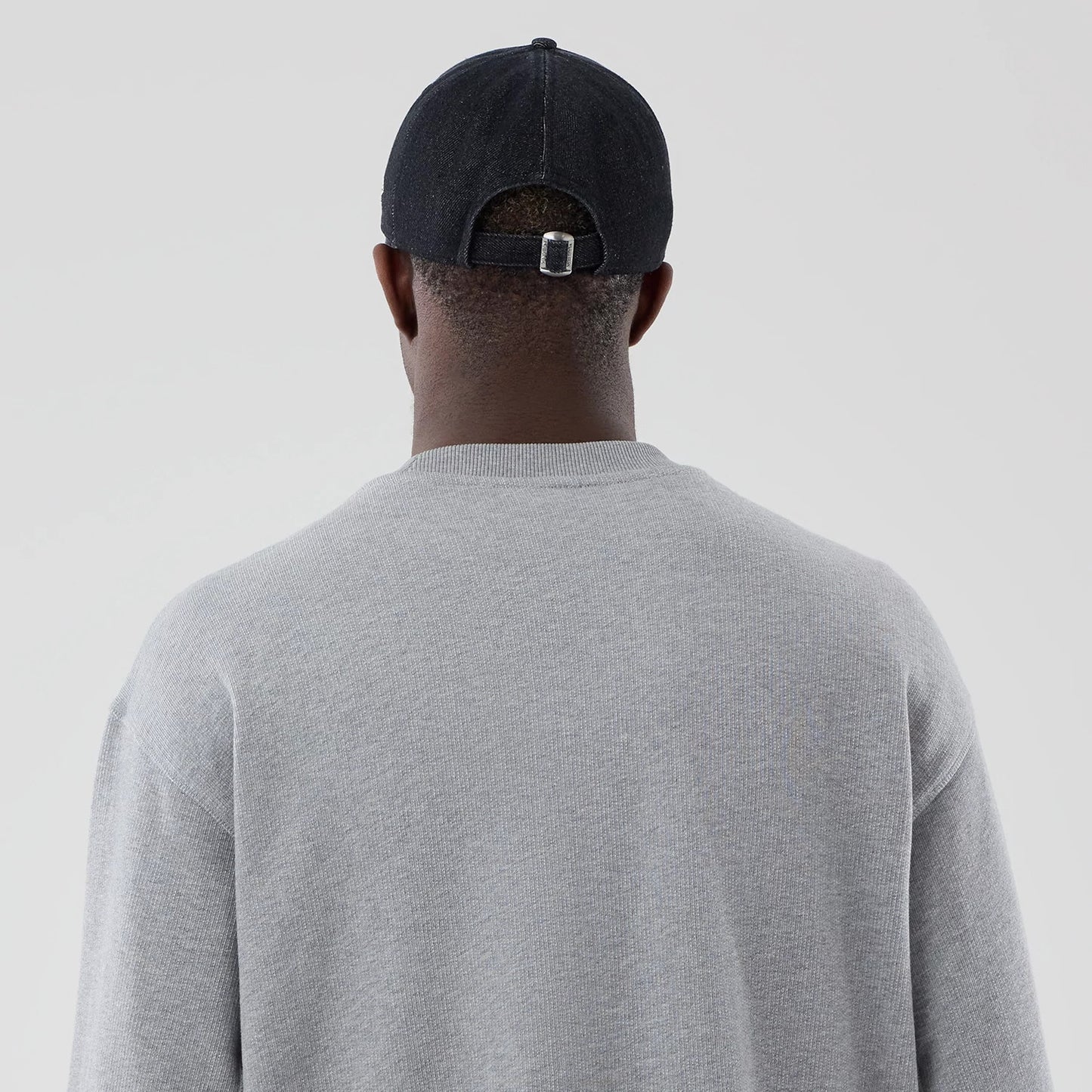 The model is wearing this New Era Oversized Crew Neck Sweater in grey. 7