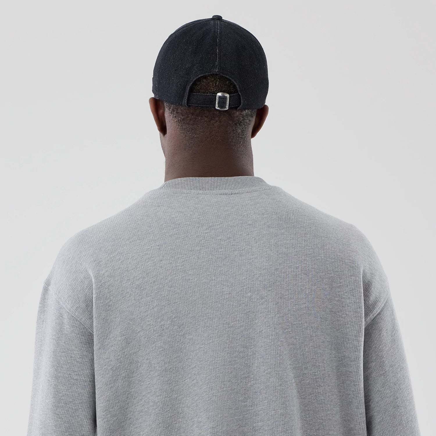 The model is wearing this New Era Oversized Crew Neck Sweater in grey. 7