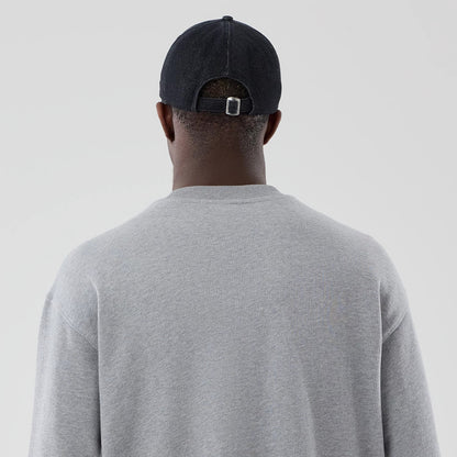 The model is wearing this New Era Oversized Crew Neck Sweater in grey. 7