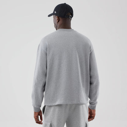 The model is wearing this New Era Oversized Crew Neck Sweater in grey. 2