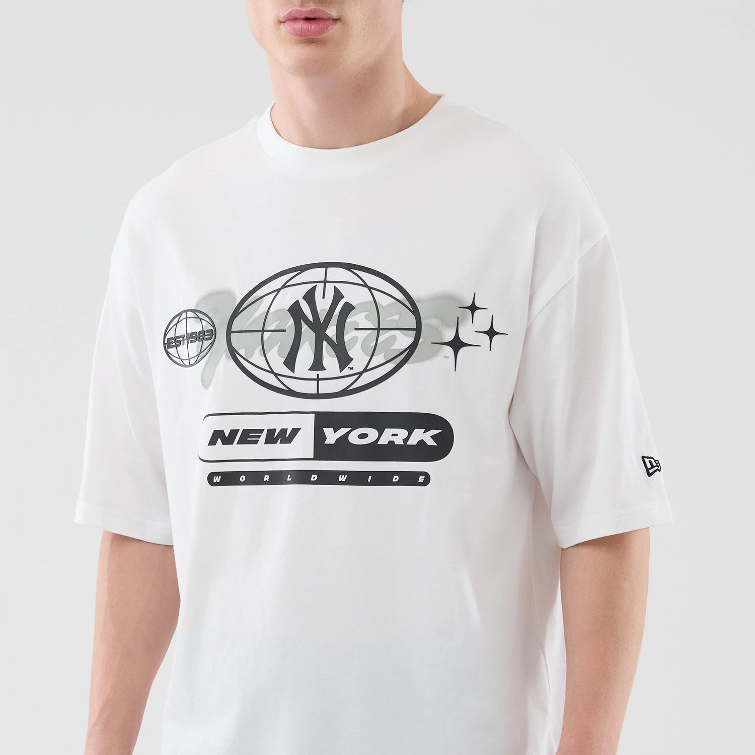 The model is wearing this MLB Logo Graphic New York Yankees Oversized T-Shirt in white. 3