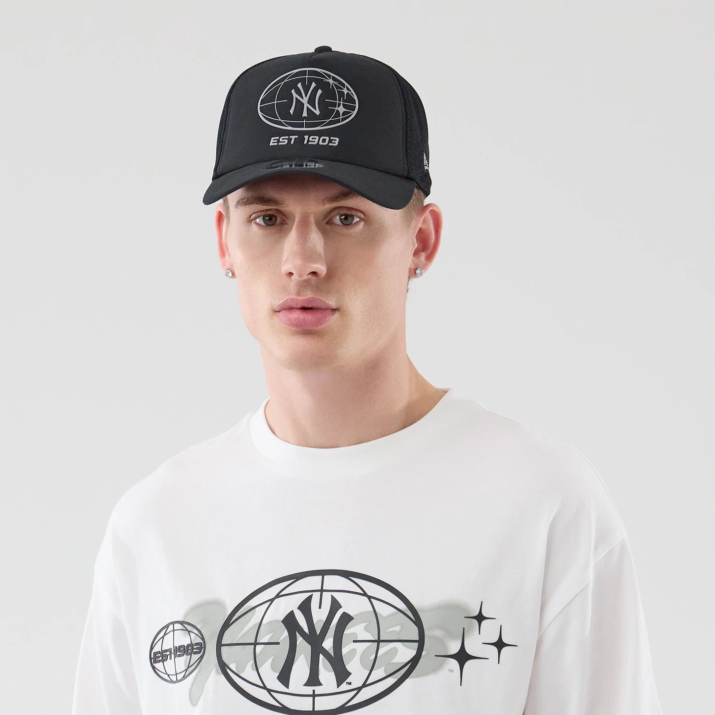 The model is wearing this MLB Logo Graphic New York Yankees Oversized T-Shirt in white. 6