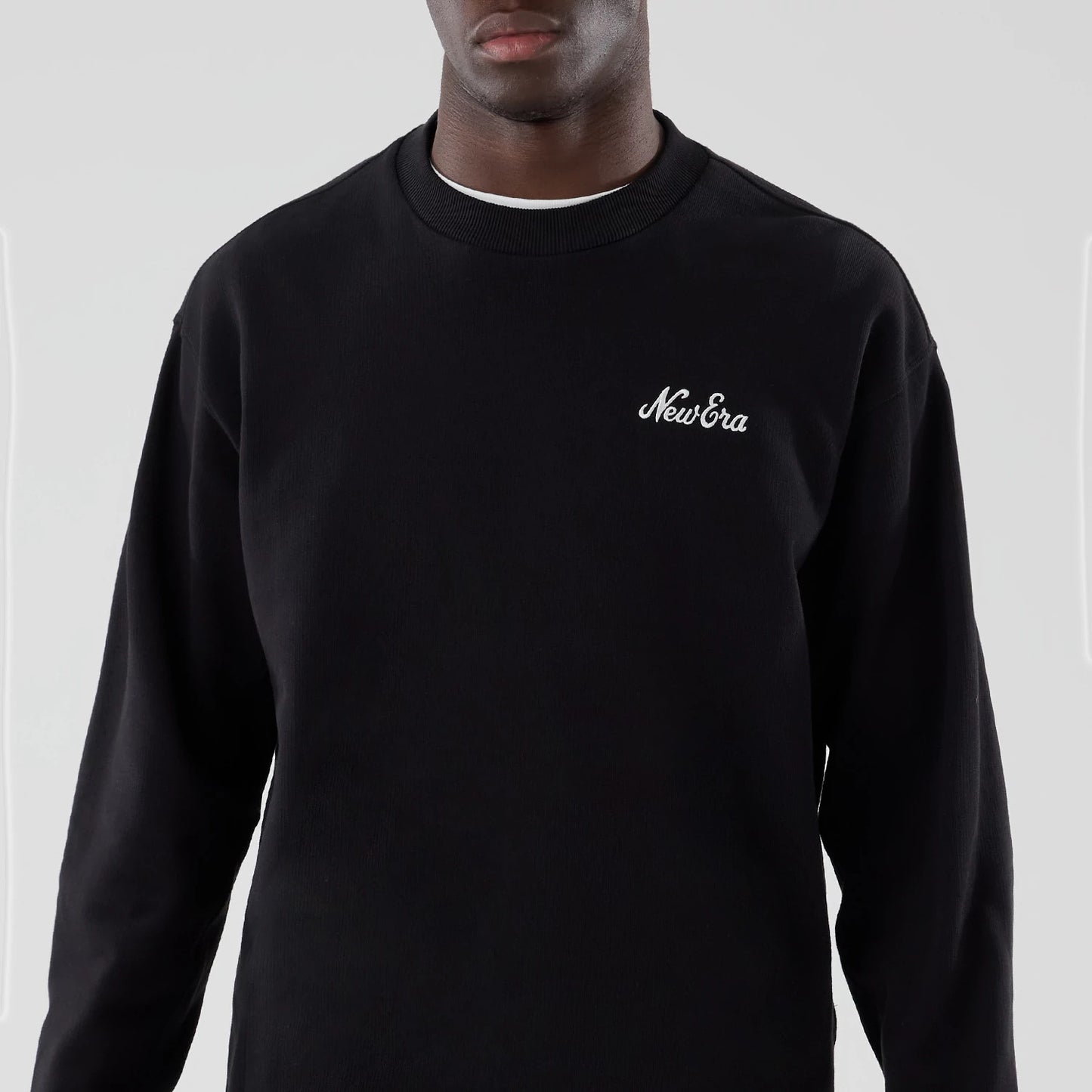The model is wearing this New Era Oversized Crew Neck Sweater in black. 3