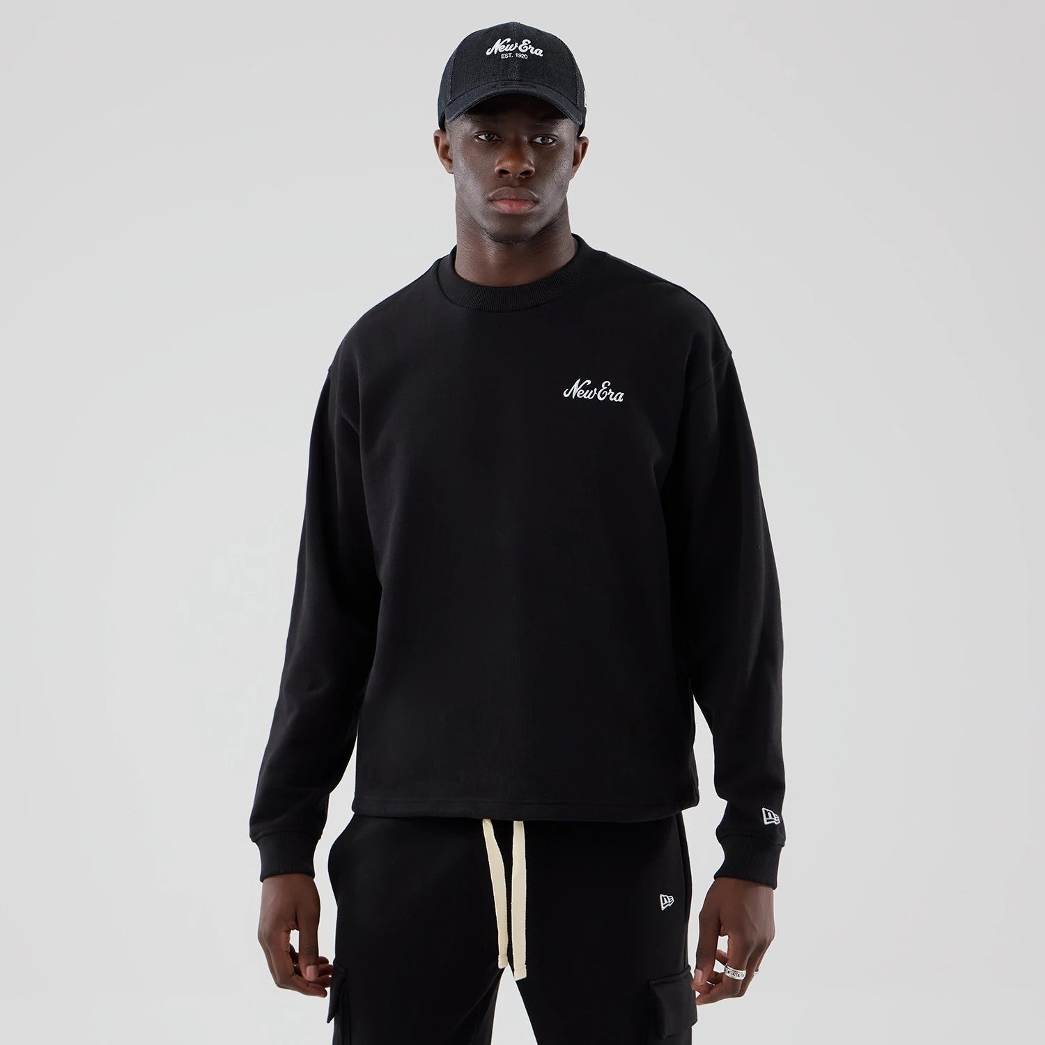 The model is wearing this New Era Oversized Crew Neck Sweater in black. 1